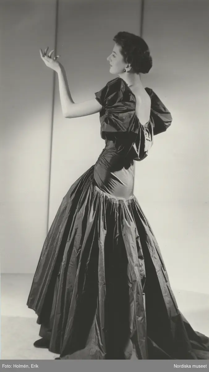 Modell poserar i hellång aftonklänning med puffärmar. Madame Grès.