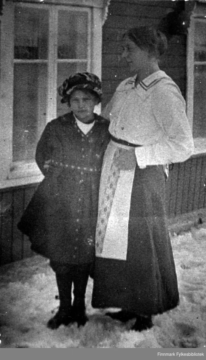 Barn og kvinne foran familien Gunnaris hus. Kvinnen er trolig tjenestepike for familien. 1920 tallet.
