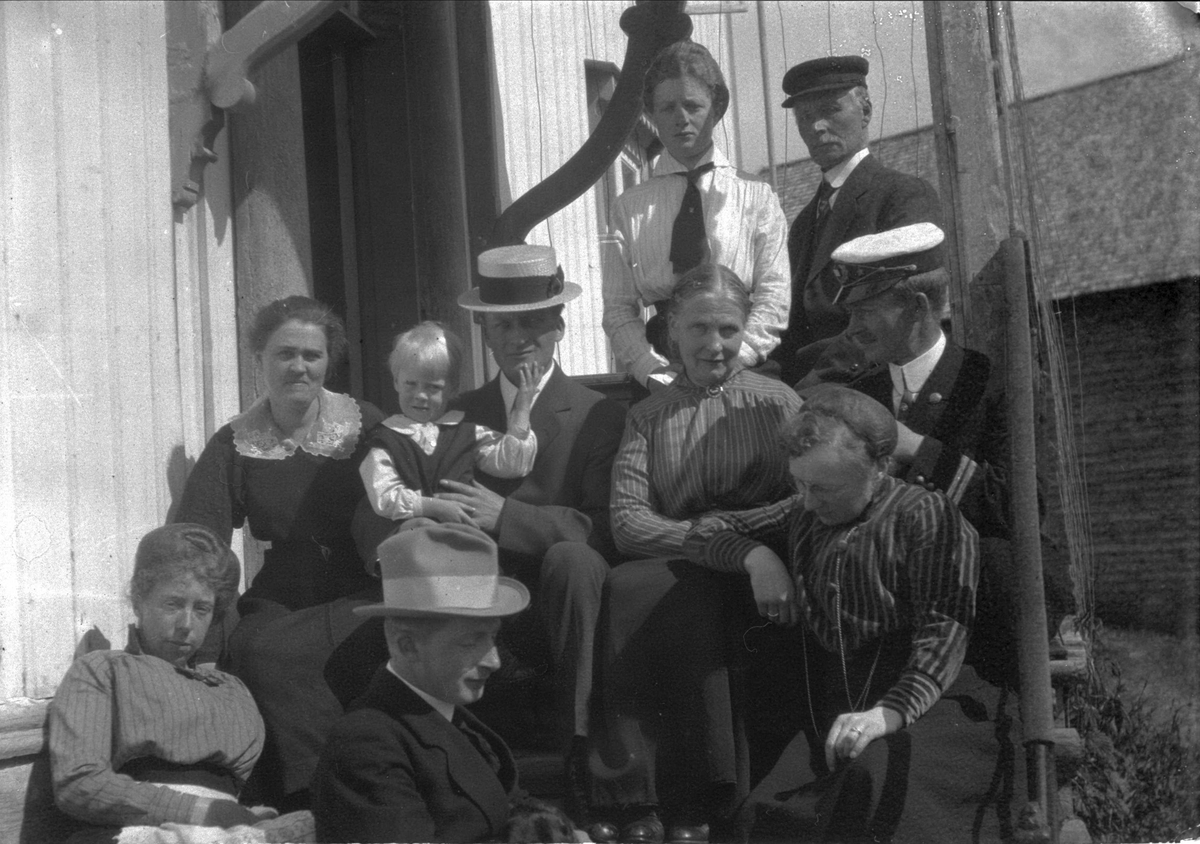 Medlemmer av familiene Norman og Pettersen samlet på trappen til et hus på Korsnes.
