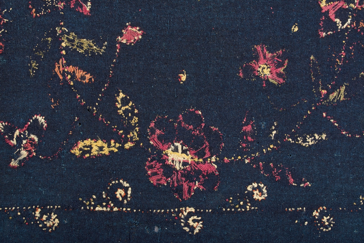 Broderad dyna på indigoblå botten. Yllebroderiet är nästan helt bortnött, men man kan urskilja ett mitt-motiv med blomkrans försedd med årtalet 1815. Från de fyra hörnen växer blommor in mot mitten. Runt dynan löper en smal bård med snurror på. I hörnen på bården är hjärt-blommor broderade. Färger på broderiet: gult, vitt, grönt, rött och blårött.
Varp och inslag:1-trådigt z-spunnet ullgarn. Varptäthet: 13 trådar per cm. Bottentyget är skarvat i ena sidan med en ca 13 cm bred remsa.Mycket rester av dun på baksidan. Märkt med Malpreparerad och 287 - 4 på två tygband. Svart tygetikett påsydd på baksidan från: "C.O. Borgs Söners Fabriker Anl. i Lund 1739". På baksidan finns också en påsydd tyglapp med texten: "A. No 100  Onsjö  Landstinget".