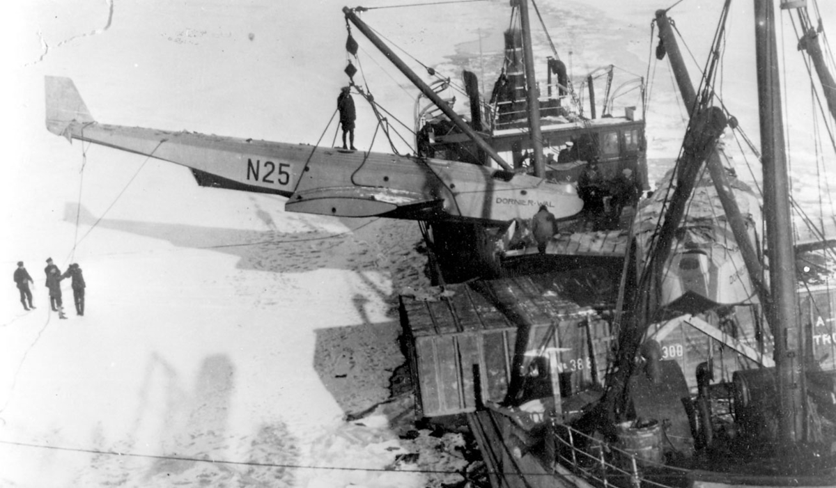 Ett fly, Dornier-Wal, "N25", Losses fra en båt, delvis demontert. Noen personer på isen, nedenfor.