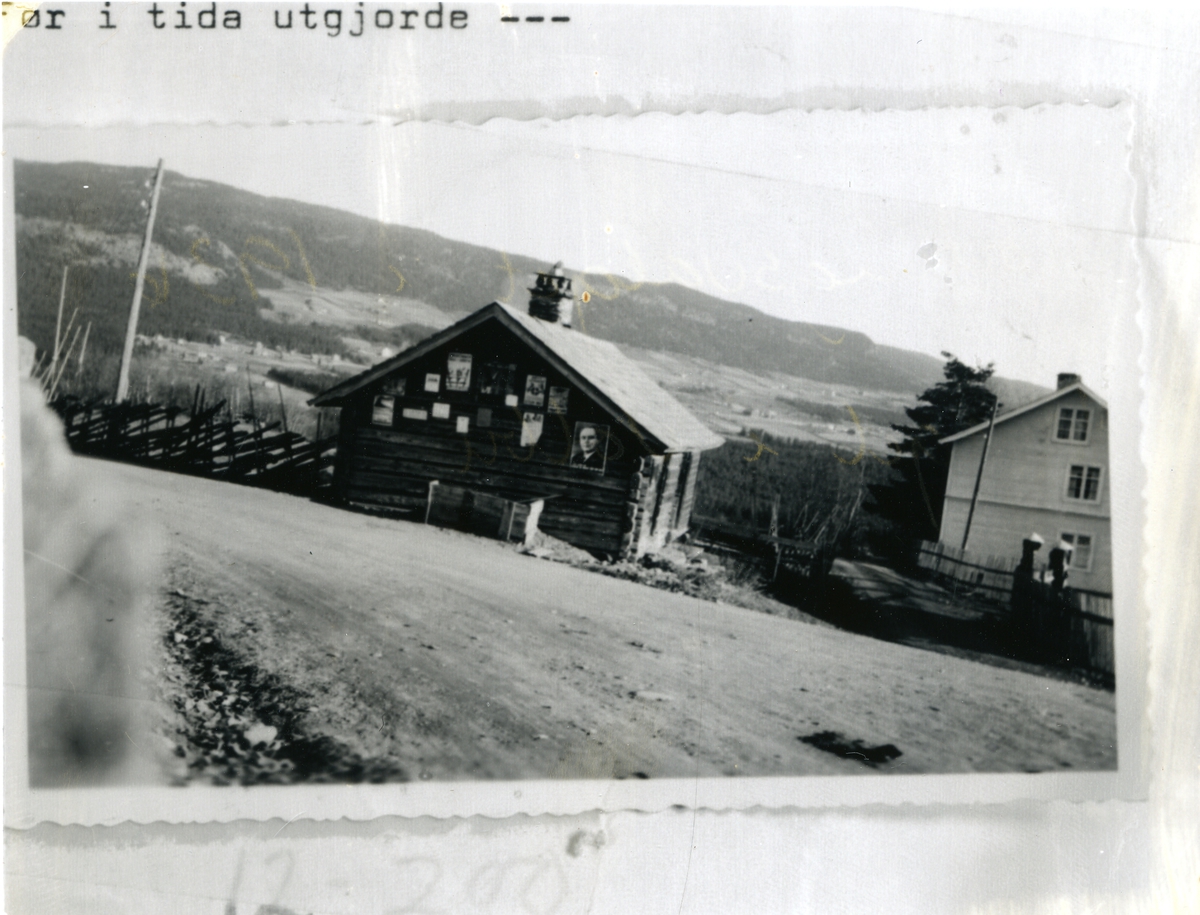 Bildet viser Torget i Volbu, Øystre Slidre. 1936. Plakatene på tømmerveggen er vedrørende stortingsvalget 19. oktober. Skigard.