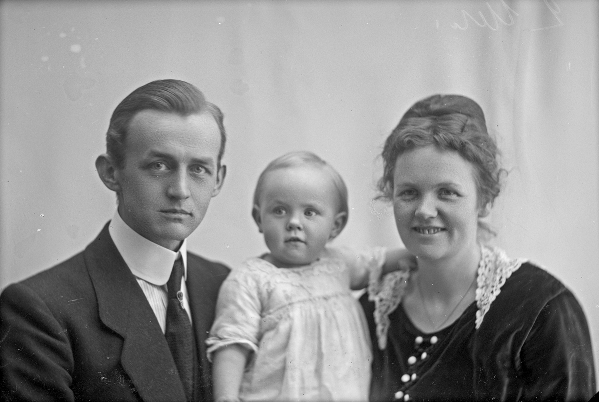 Familiebilde av en far, en mor og et lite barn. Bestilt av Arnold Johnstad.