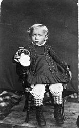 Studioportrett av barn på en stol.