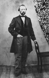 Porterett av Lauritz Lassen Brodtkorb. Han står ved en stol,