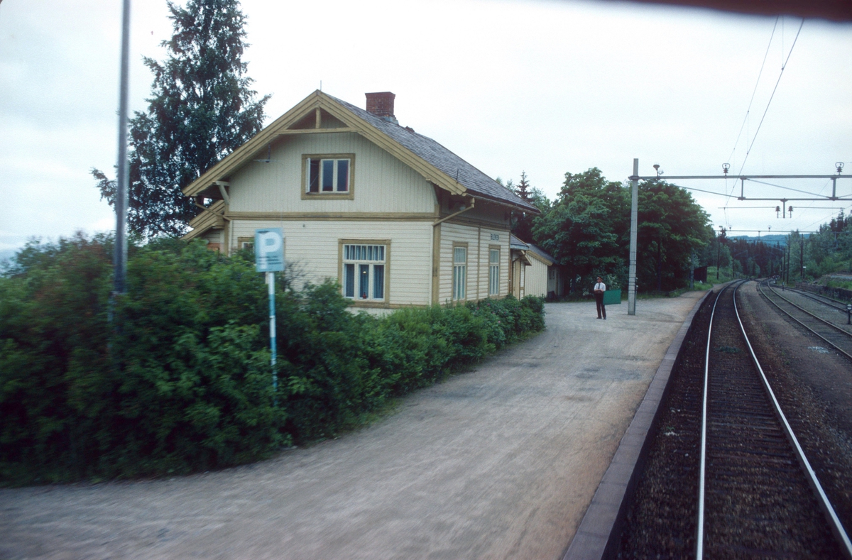 Togekspeditøren på Bleiken stasjon viser signal "Passer" (grønt flagg) til godstog 5173 (Roa - Eina).