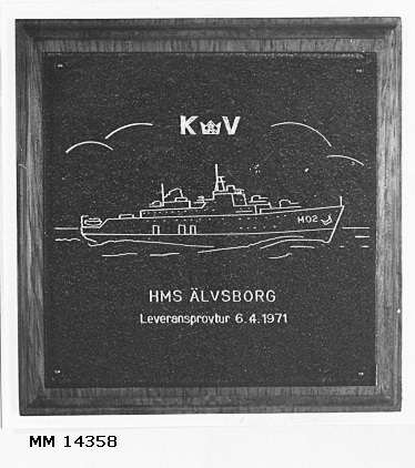 Minnestavla av mässingsplåt med motiv: Minfartyget Älvsborg och med texten "HMS ÄLVSBORG Leveransprovtur 6.4.1971". Plåten fastsatt på platta av trä.