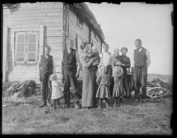 Familie-gruppebilde ved husvegg