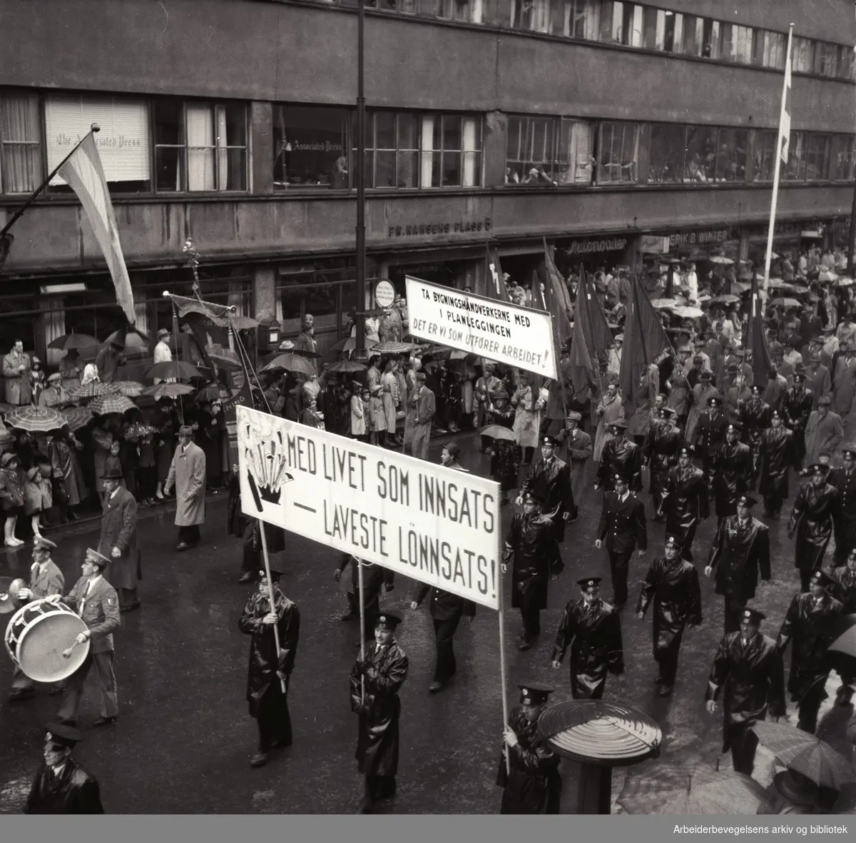 1. mai 1953 i Oslo.Demonstrasjonstoget.Parole: Med livet som innsats-- Laveste lønnssats!.Parole: Ta bygningshåndverkerne med i planleggingen. Det er vi som utfører arbeidet!...
