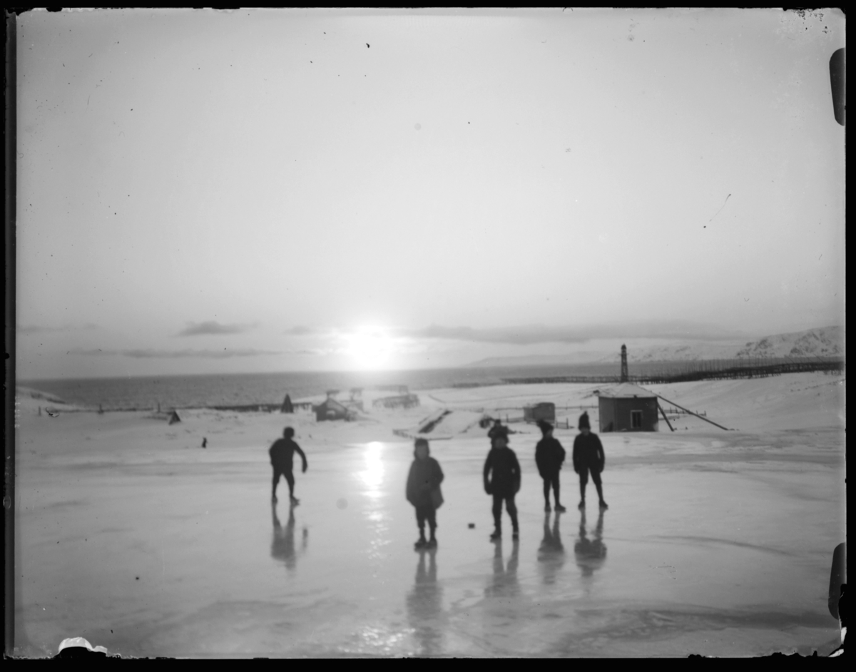 Vinter i Vardø. Fem gutter på isen, lav sol