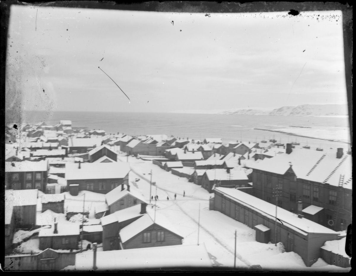 Bebyggelsen i Vardø antakelig fotografert fra kirketårnet. Bildet er tatt nedover Søndre Langgate, mot Søndre våg. Den store bygninga til høyre i bildet er rådhuset og samlaget, som var samlokalisert. Det ligger mye snø i gatene