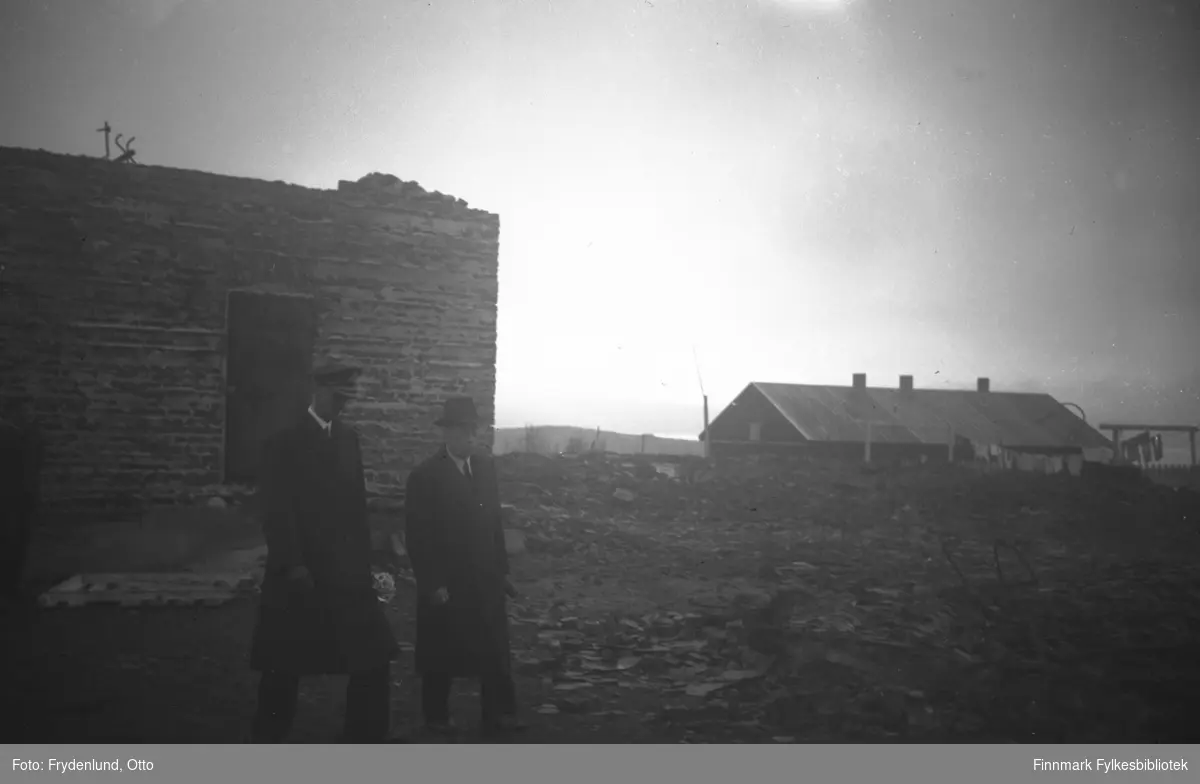 Fylkesmann Gabrielsen og Kong Haakon VII ved ruinene av fylkesmannsgården i Vadsø 12. juli 1946. I bakgrunnen står ei brakke med klesvask til tørk utenfor