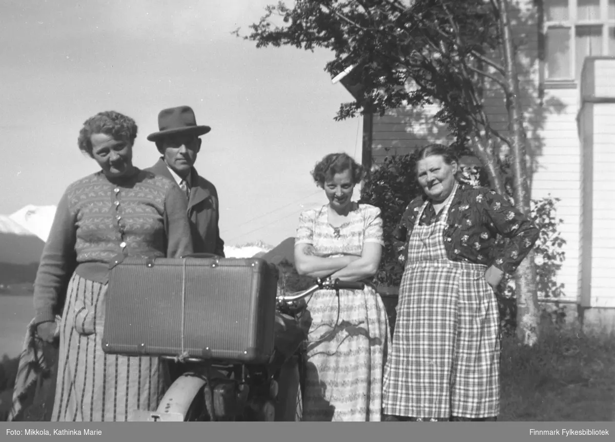 Tre kvinner og en mann med hatt og frakk samlet rundt en moped med koffert på bagasjebrettet. Mopeden har skilt som begynner på T. Fra venstre: Bergljot, Petter, Aslaug og Astrid Kornberg på Kornberg, Sunnmøre