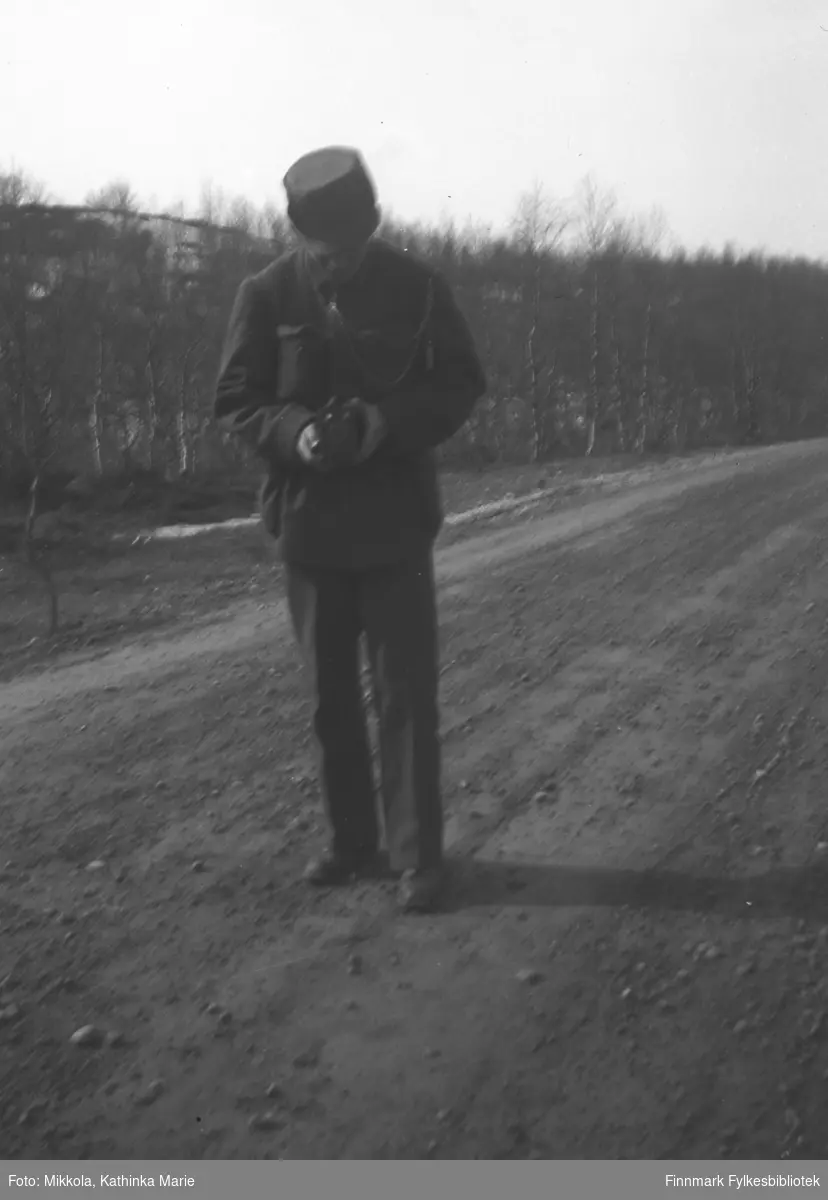 Dette kan være en tysk soldat på veien ved Mikkelsnes. Det ser ut til at han stiller inn et kamera
