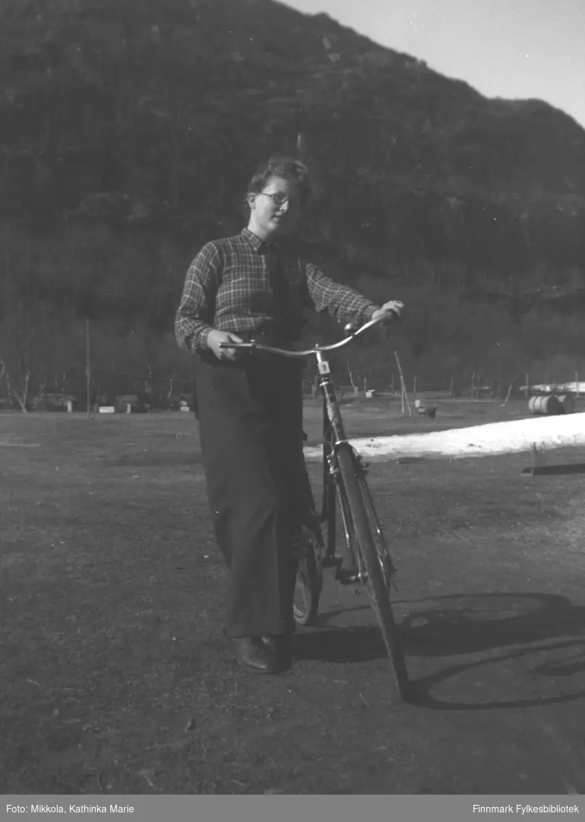 Ingrid Mikkola med sykkel på tunet til Mikkelsnes en vårdag.
