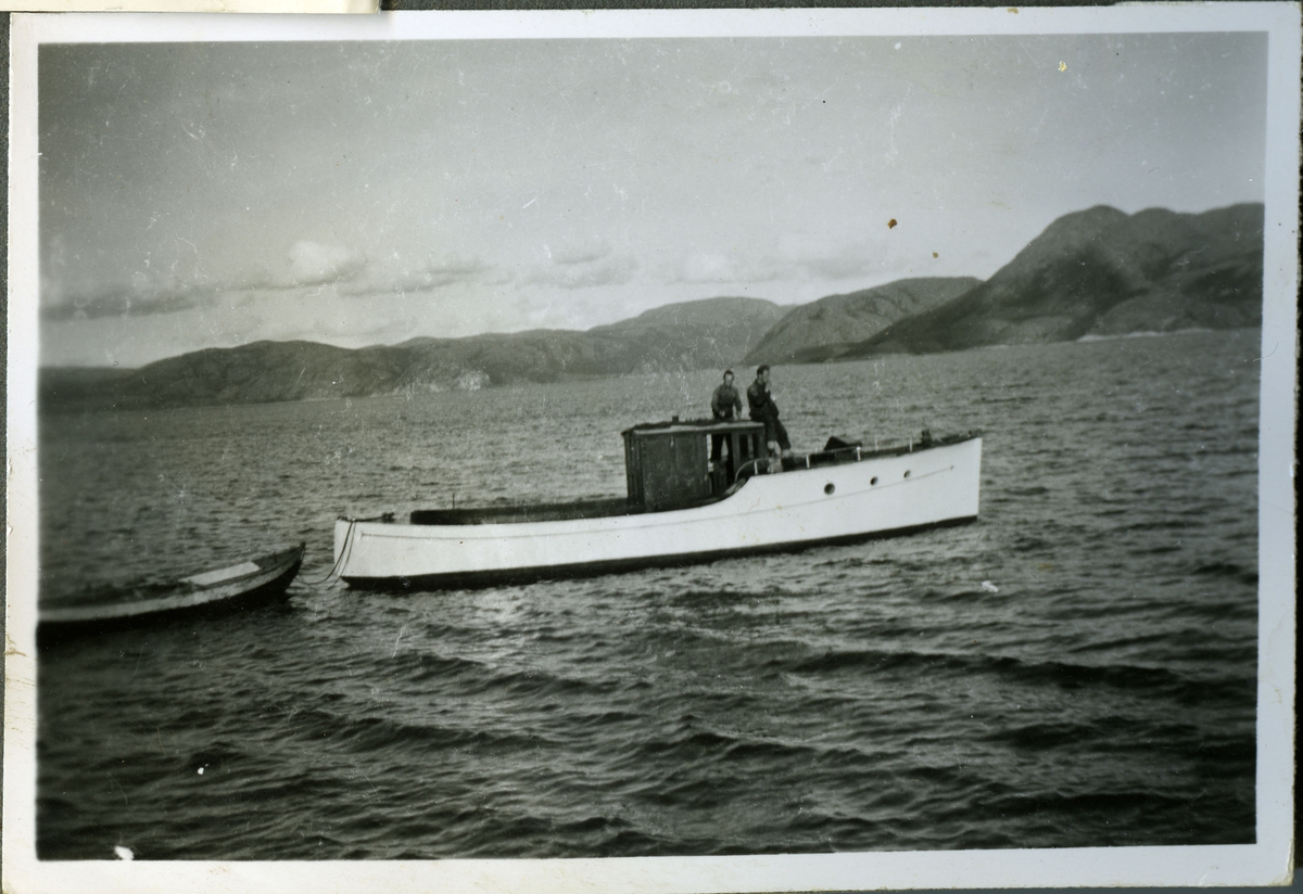 Skiferbruddet i Friarfjord opererte med egen båt til transport. Her ser man to menn ombord i båten som ligger for anker, med en liten robåt er festet bak. Mennene ombord er Terje Reeberg og Jacob Reeberg.