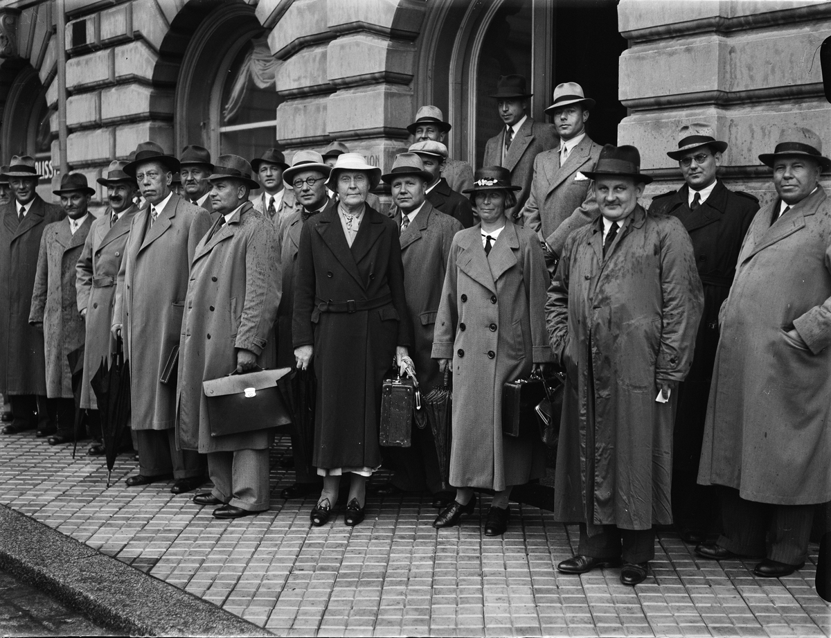 Grupporträtt - kvinnor och män utanför polisstationen i Uppsala stads rådhus, Vaksalagatan, Uppsala 1938