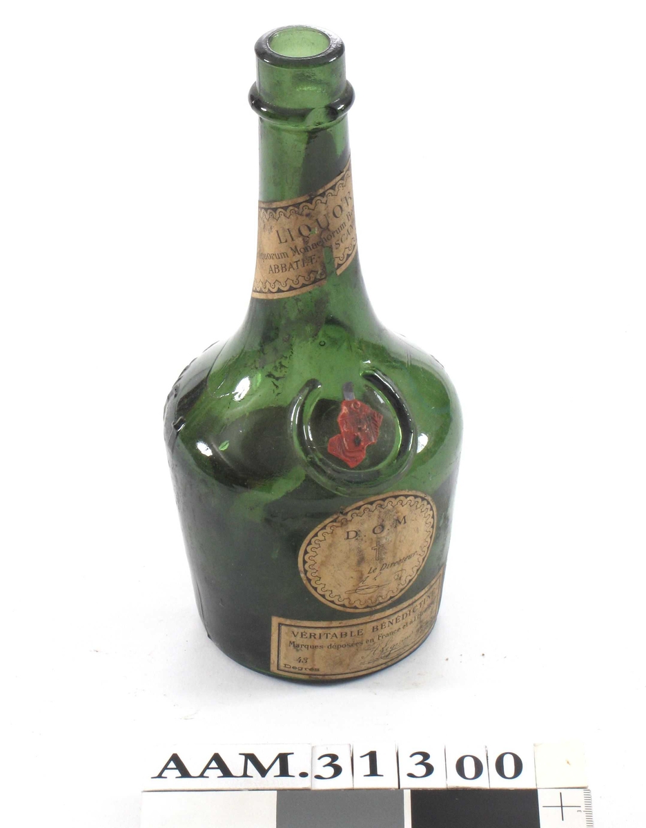 Flaske med sirkelformet bunn, lav "kropp" og lang hals. Rest av forseglingsstempel av lakk.