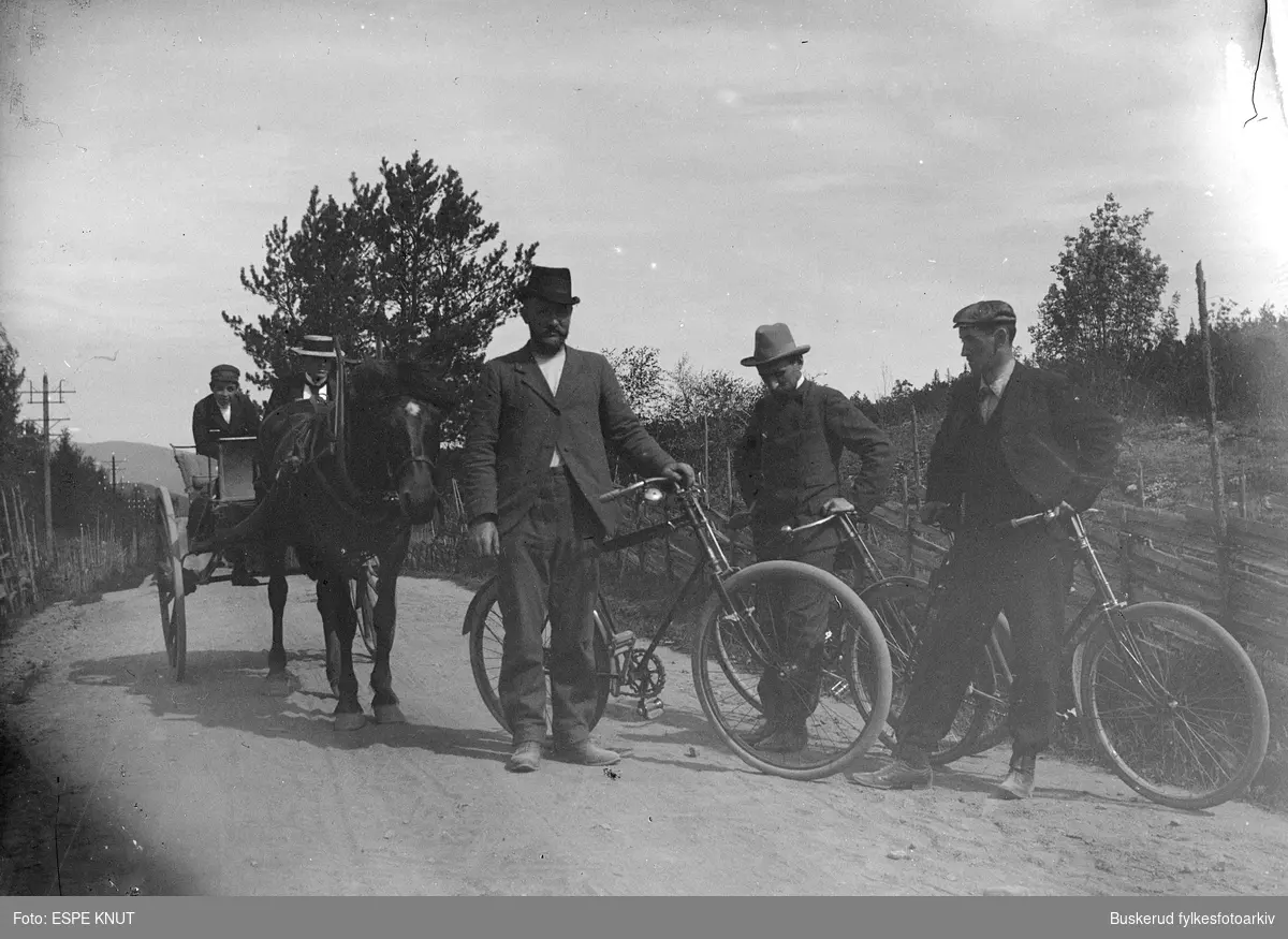 Tre menn på sykkel sammen med personer til hest