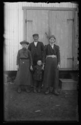 En mann med to jenter og en liten gutt fotografert foran et 