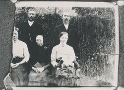 Gruppeportrett av familien Halvorsæther framfor et hesjegjer