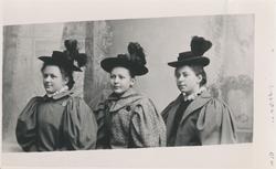 Portrett av tre jenter i finklær.