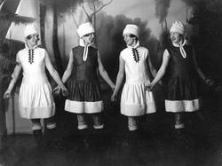 Fire kvinner i kostymer på en revyscene.