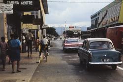 Biler og fotgjengere i en gate.