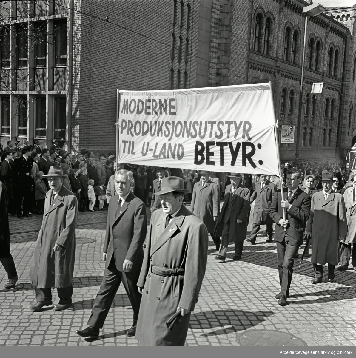 1. mai 1964 i Oslo.Demonstrasjonstoget i Karl Johans gate.Parole: Moderne produksjonsutstyr til U-land betyr: