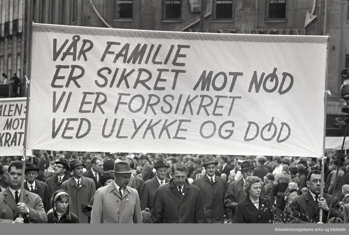 1. mai 1966 i Oslo.Demonstrasjonstoget i Karl Johans gate.Parole: Vår familie er sikret mot nød.Vi er forsikret ved ulykke og død