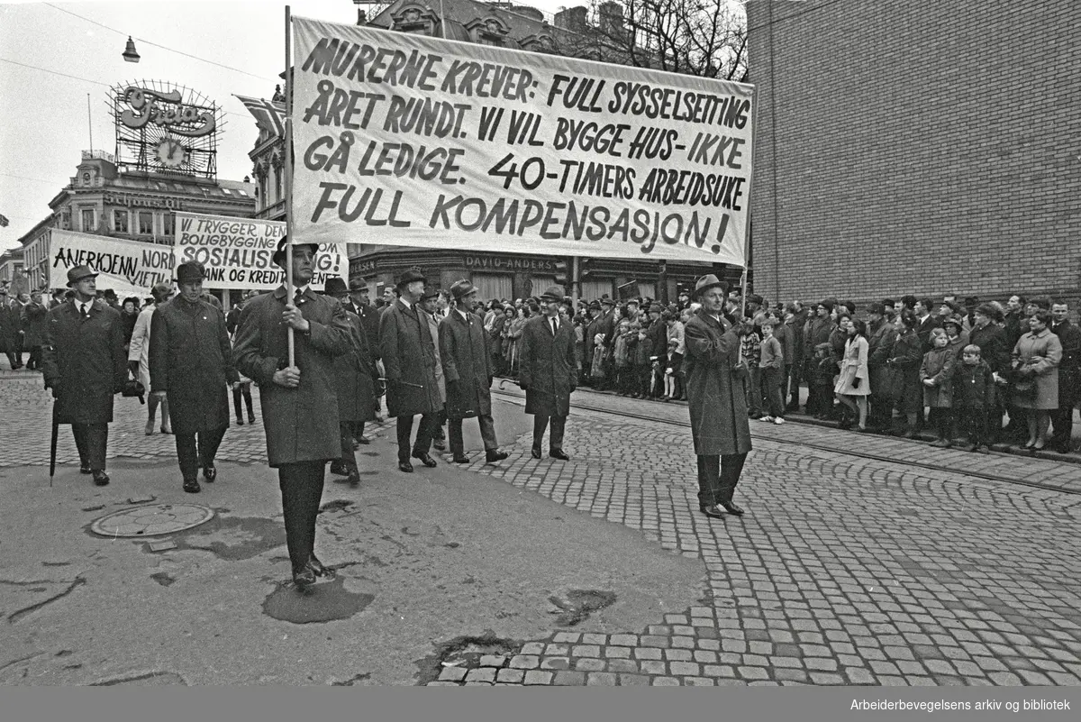 1. mai 1969 i Oslo.Demonstrasjonstoget i Karl Johans gate.Parole: Murerne krever: Full sysselsetting året rundt. Vi vil bygge hus- ikke gå ledige. 40-timers arbeidsuke..Full kompensasjon!