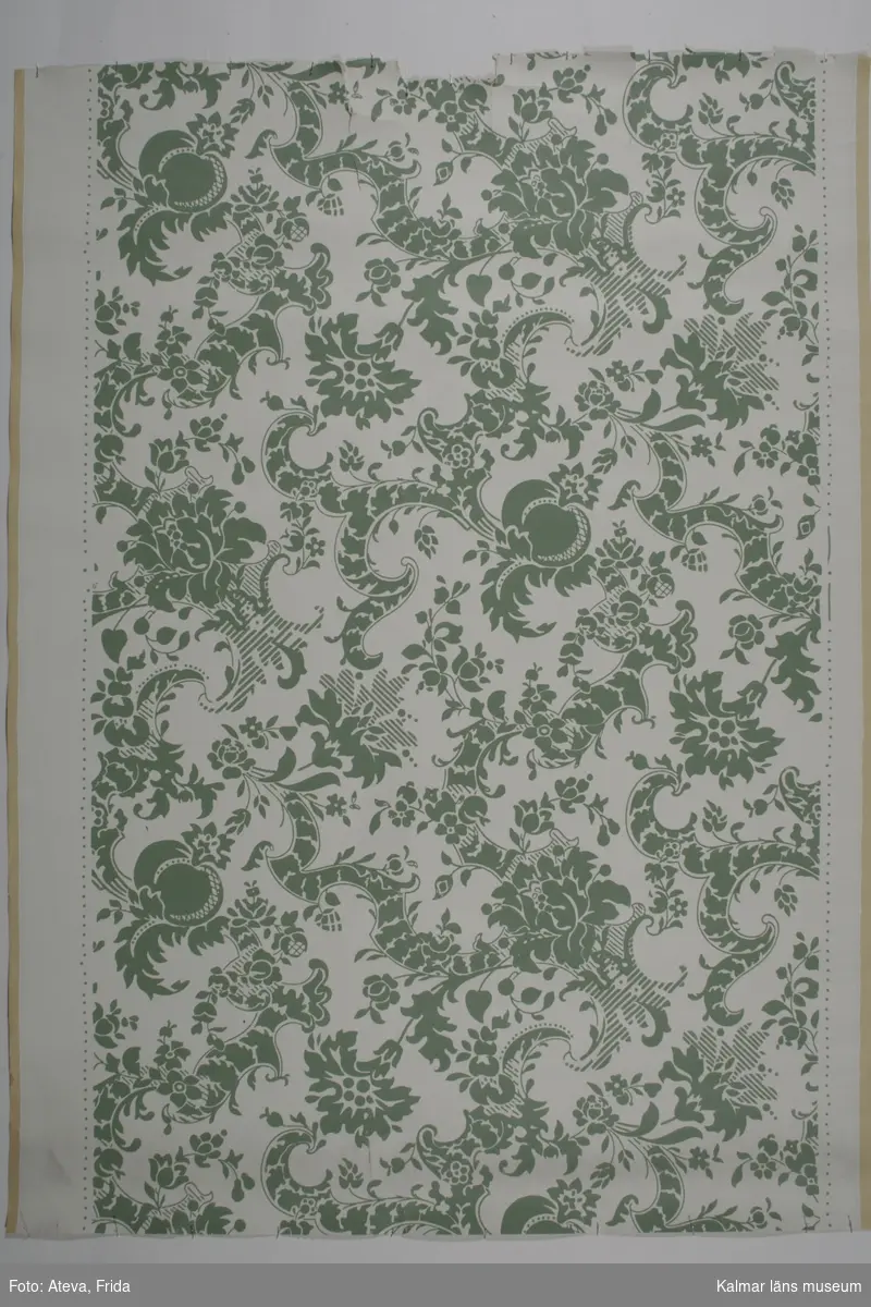 KLM 28760:7:1. Tapet av papper. Tapet med kittvit bottenton och stiliserat blommönster i grönt (Kåberg SH 200). Datering: 1970.