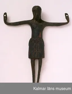 KLM 7960. Kristusbild. Av brons. Kristusbild avsedd att fästas på krucifix, gjuten med ihålig baksida. Långt ländkläde om midjan.