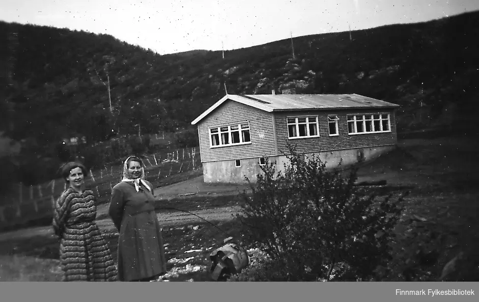 Skolen i Smalfjord. To kvinner står ved skolen. Fra venstre Gjerdrud Betten og fru Dalsbø. Gjerdrud Betten var lærer ved Sieda skole og reiste til Smalfjord for å undervise i handarbeid og skolekjøkken.