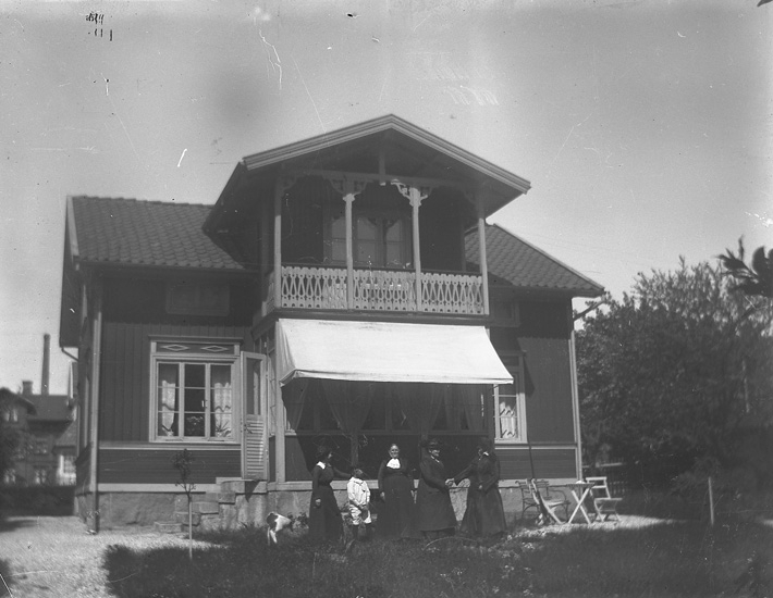 Familj samlad framför bostaden. - Bohusläns museum / DigitaltMuseum