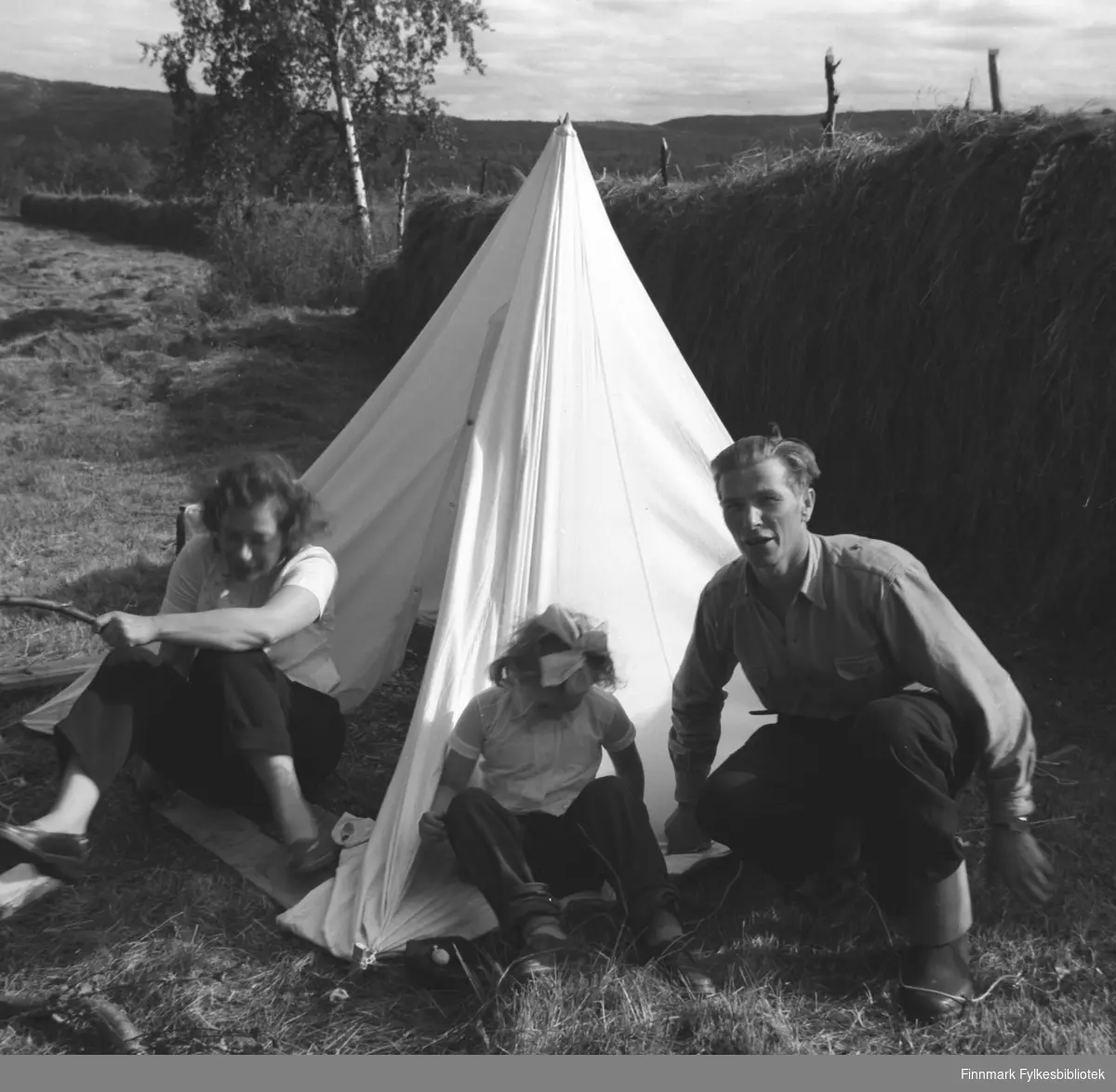 Familien Drannem utenfor et telt i Øvre Neiden. Slåttedugnad?