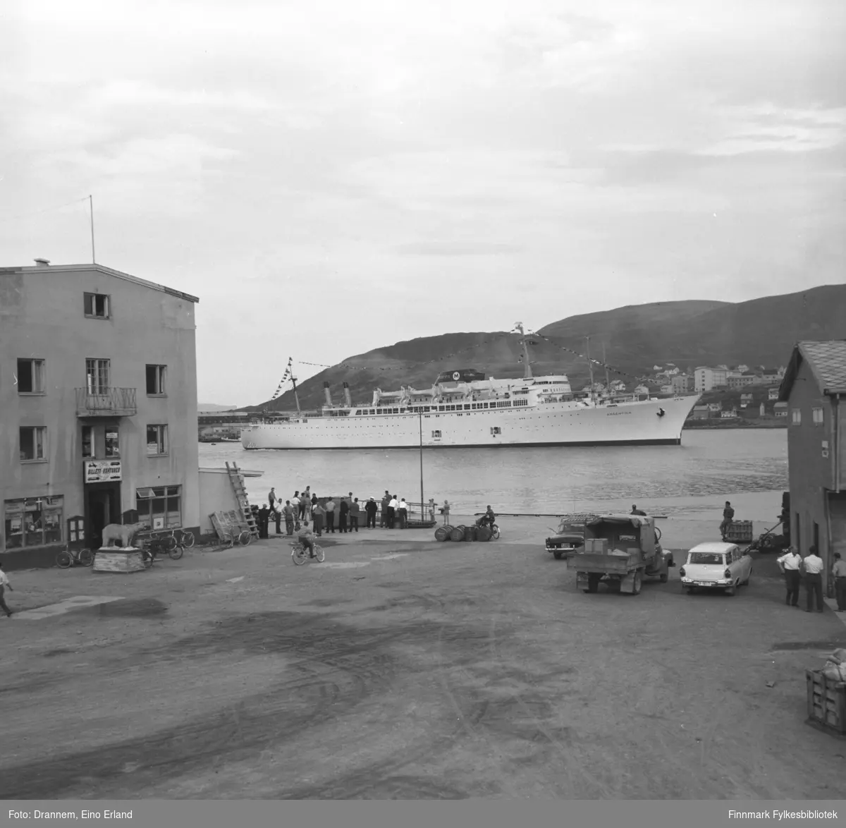 Turistskipet Moore-McCormack Lines (T-S/S turbo dampfartøy), Argentina nærmer seg Hammerfest havn. Utstoppet isbjørn på sokkel ute til venstre, hvit Ford Taunus 17M stasjonsvogn 1958-1960 ute til høyre.