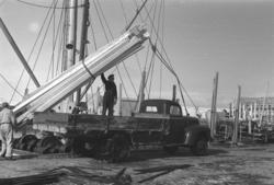 Bilde fra havna i Vardø påsken 1947. En båt losser material 