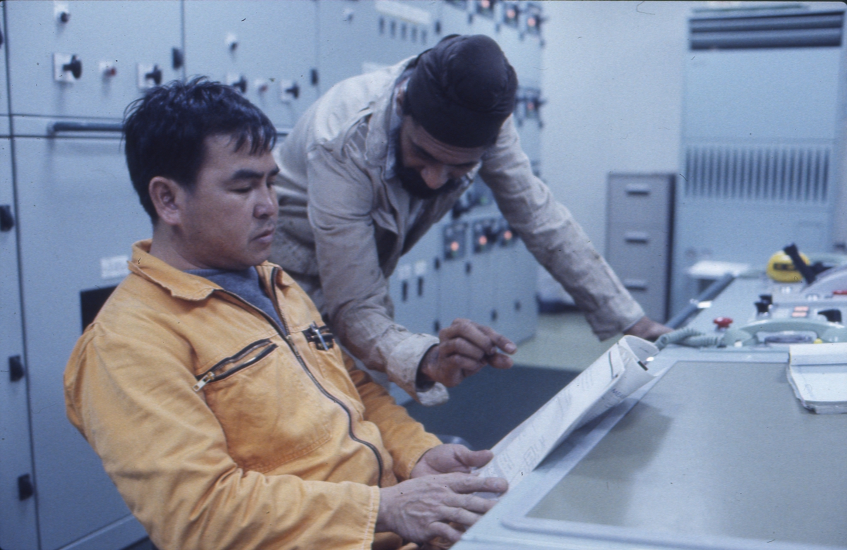 Elektriker og maskinist diskuterer i kontrollrommet på M/S 'Westwood Jago' (b. 1987, Ishikawajima H. I., Aioi, Japan).