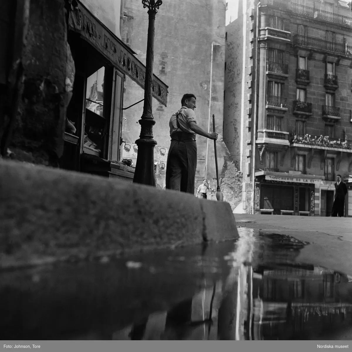 Paris. Gatustädare, reflektioner i vattenpöl.