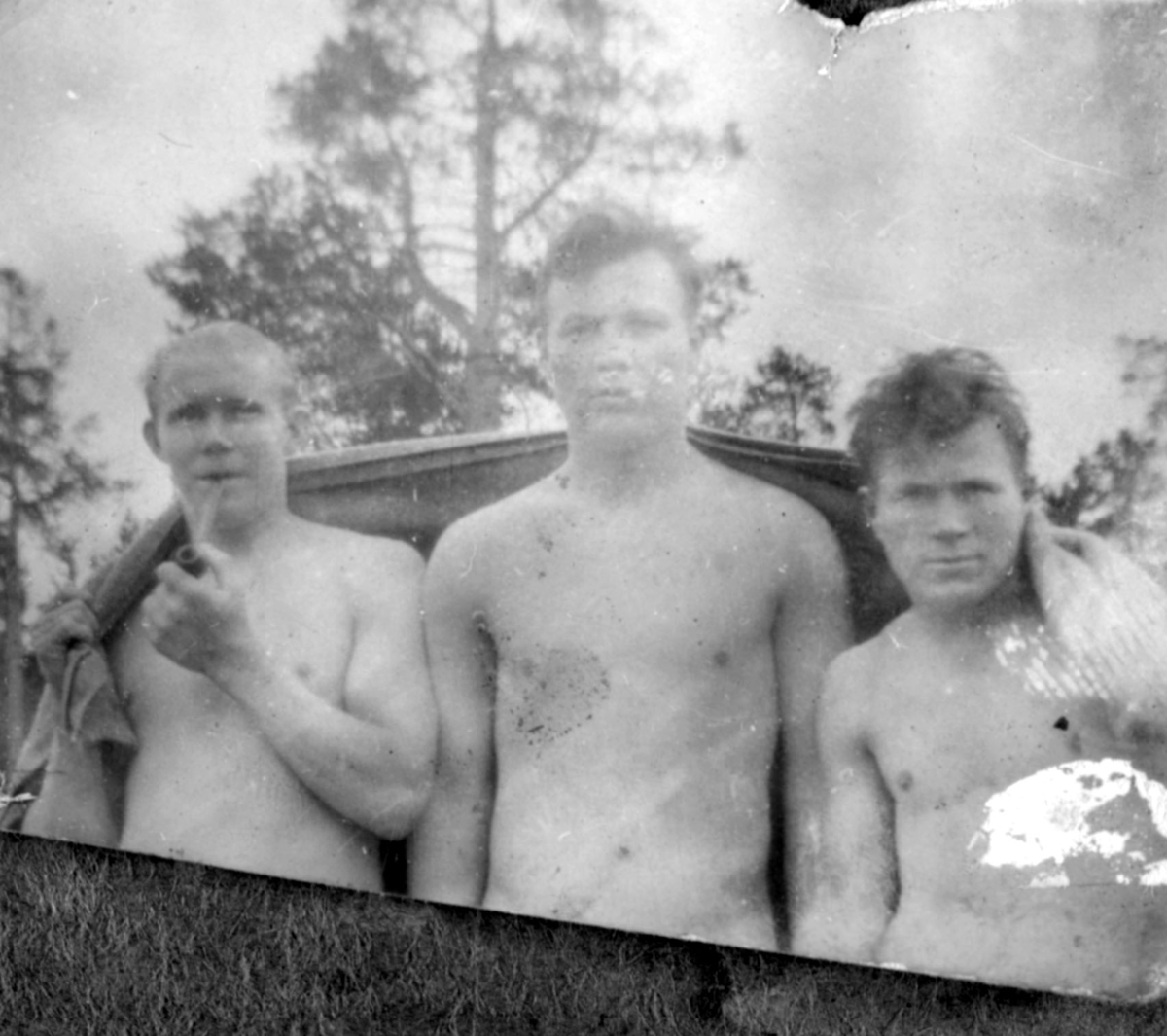 Tre ukjente menn i bare overkropper fotografert en sommerdag, muligens i Kvalsund kommune.