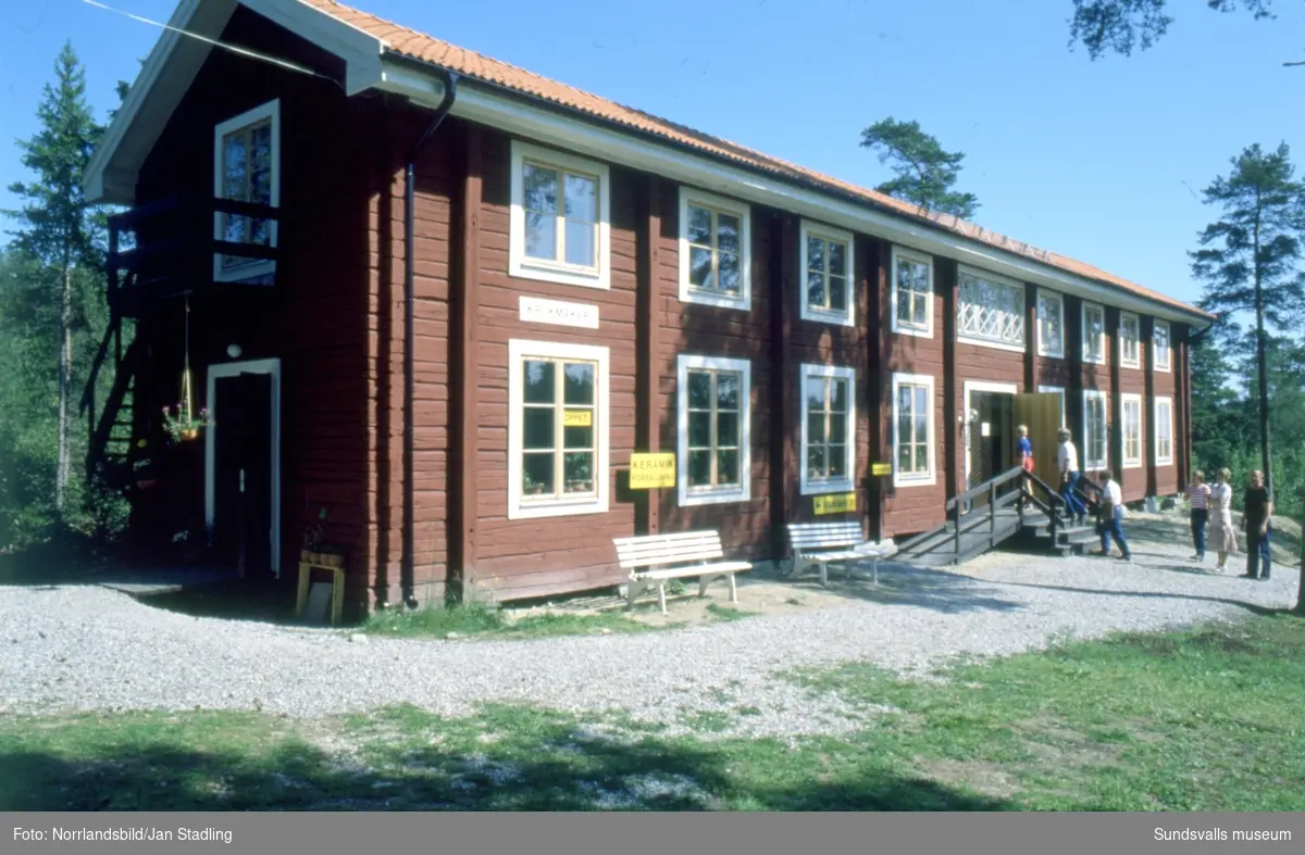 Sommarbilder från Norra bergets friluftsmuseum med byggnader, getter, butik, krukmakeri och besökare.