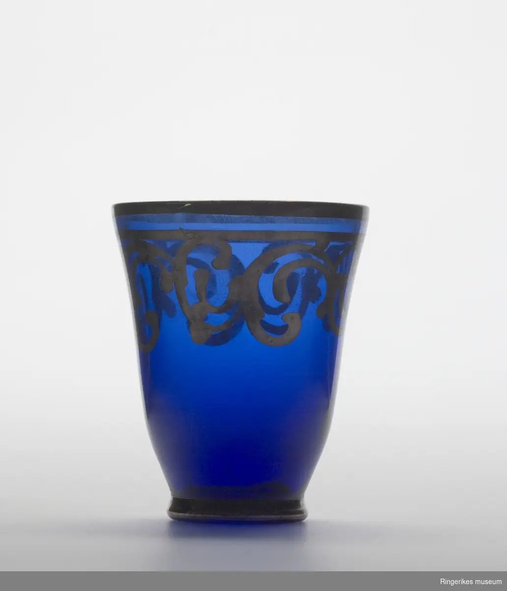 Drammeglass i blått glass med gulldekor.

Et sett som inneholder karaffel og åtte glass.