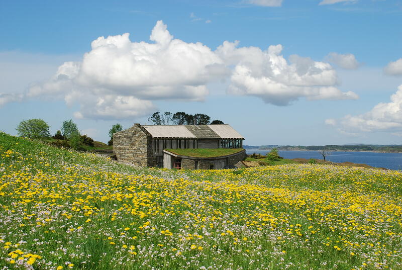 Bygning i idyllisk landskap med blomstereng, Lyngheisenteret på Lygra