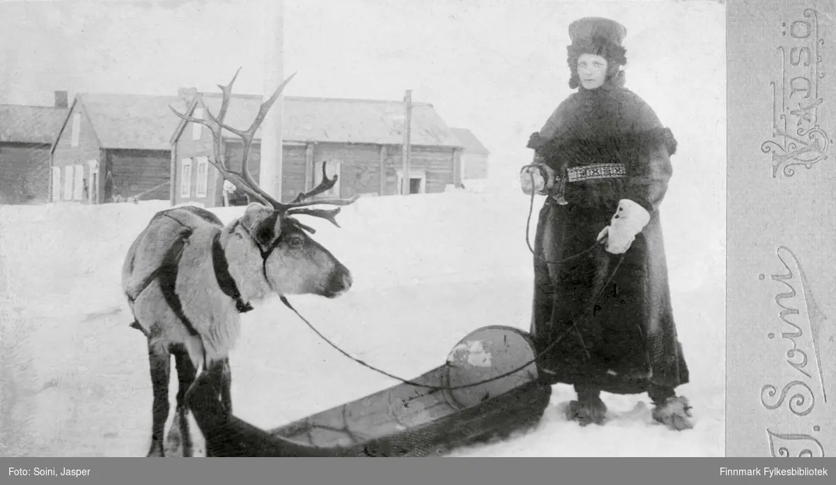 Bildet viser Ragna Olsen med rein og pulk år ca. 1900. Ragna Olsen har njalfahtta på seg, som er en variant av luhkka uten hette. 
