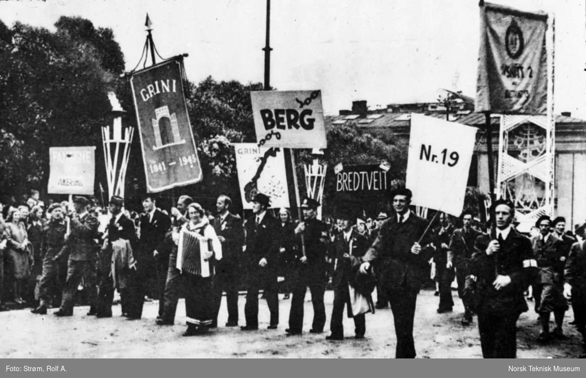 Opptog, frigjorte fanger fra fangeleirene med faner med navn på fangeleirene Grini, Berg, Bredtvedt og Møllergata 19, opp slottsbakken, Oslo, mai 1945,