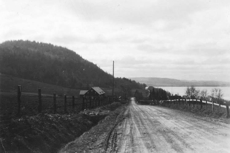 Vägen från Gisebo mot Huskvarna. Till höger syns Vättern. Nedanför backen ligger Strands gård, Skärstad. Ladugård till vänster och bostadshus mm till höger.