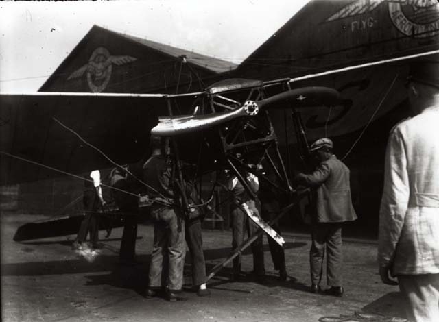 En grupp män mekar med ett flygplan på Thulins flygskola.