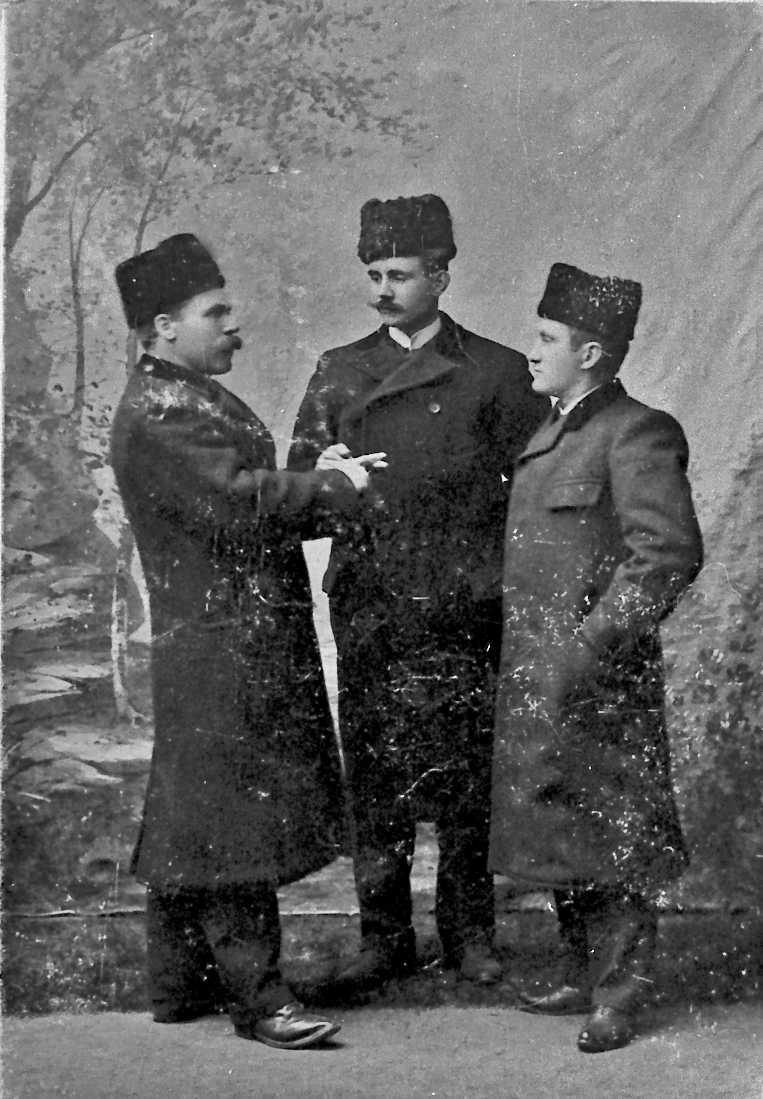 Portrett av tre finkledde menn.