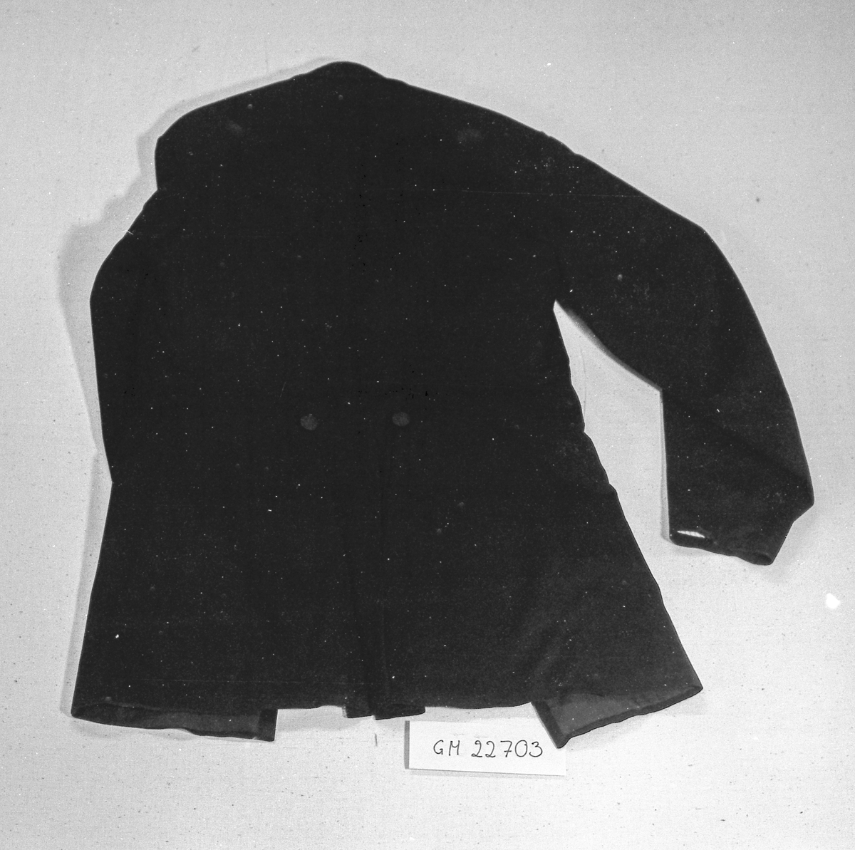 Dobbeltspent jakke, med to rader knapper som er trukne, trolig av ull og håndsydd